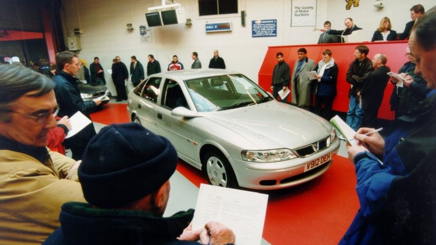 Image of man reviewing vehicle before purchase at a car auction.